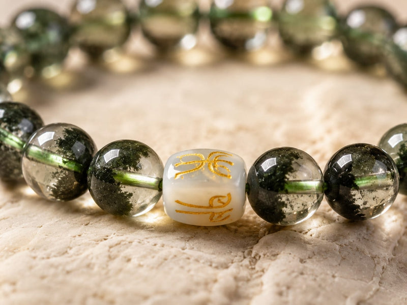 Close-up of a Green Phantom Quartz Bracelet highlighting the San He Wood formation bead with gold detailing, emphasizing meticulous craftsmanship and high-quality finish.