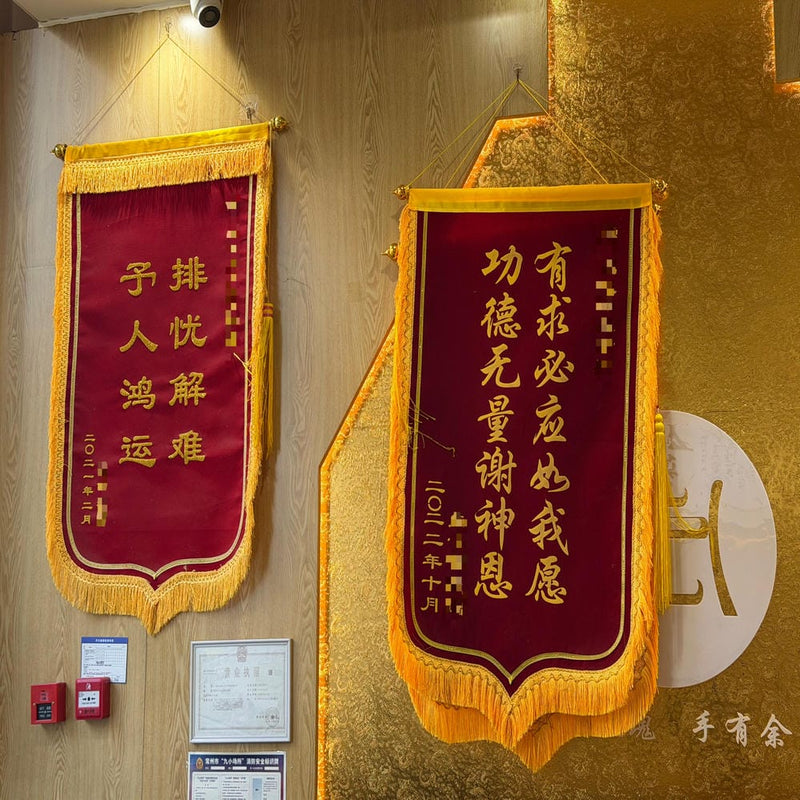 Red and gold client appreciation banners hanging on a wall, showcasing testimonials and recognition of oracle guidance services.