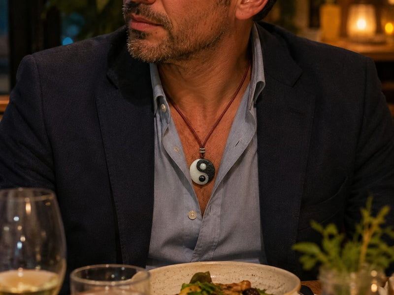A man wearing a Taiji Yin Yang pendant with a blazer and open-collar shirt during a casual business dinner, showing an everyday professional styling idea.