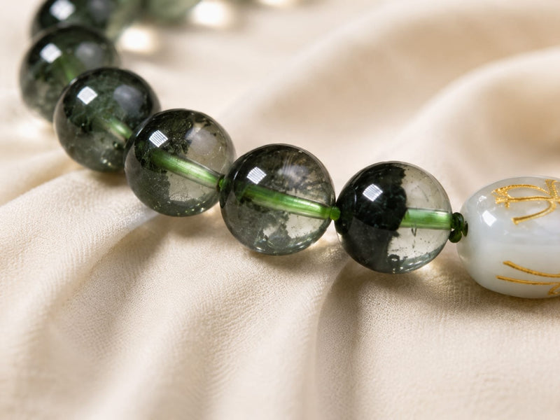 Close-up of Green Phantom Quartz Bracelet beads with a Hetian jade formation charm, showing the natural green inclusions and symbolic bead arrangement for prosperity and support.
