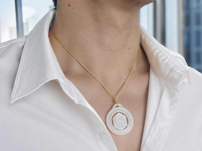 Close-up of a male wearing the Heavenly Blessing Talisman Pendant on a gold cord, showing the pendant resting against a white shirt and highlighting its smooth jade surface and engraved details.