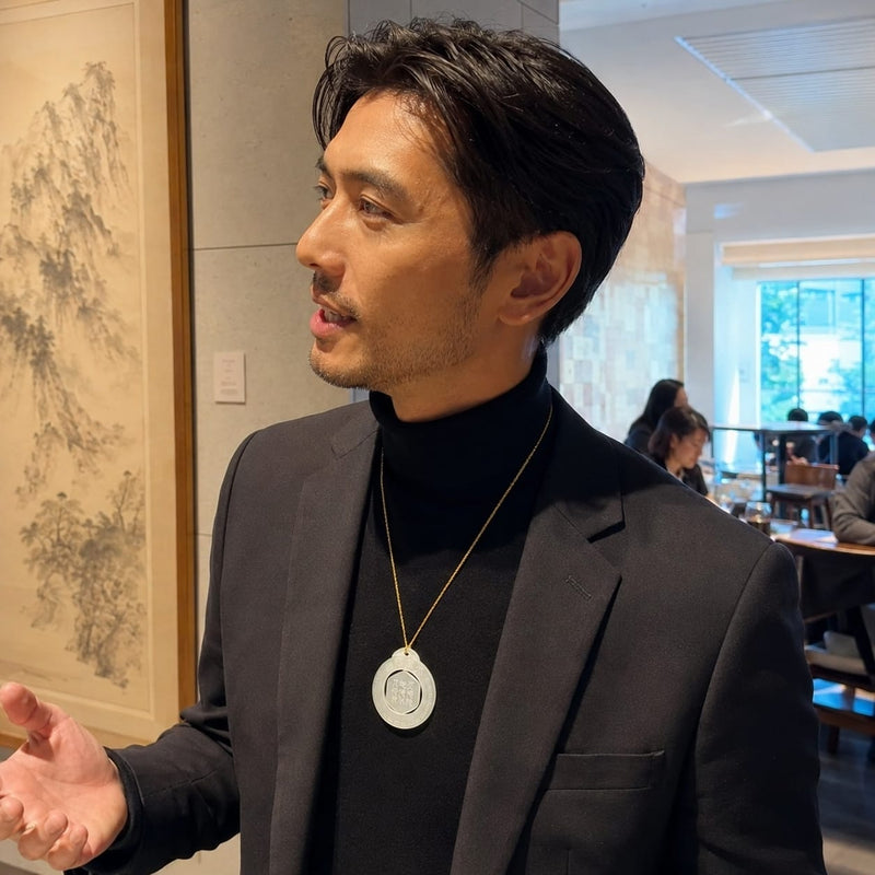 An American-Chinese man wearing the Heavenly Blessing Talisman Pendant at a cafe, emphasizing the pendant’s polished craftsmanship and understated elegance for mindful everyday use.
