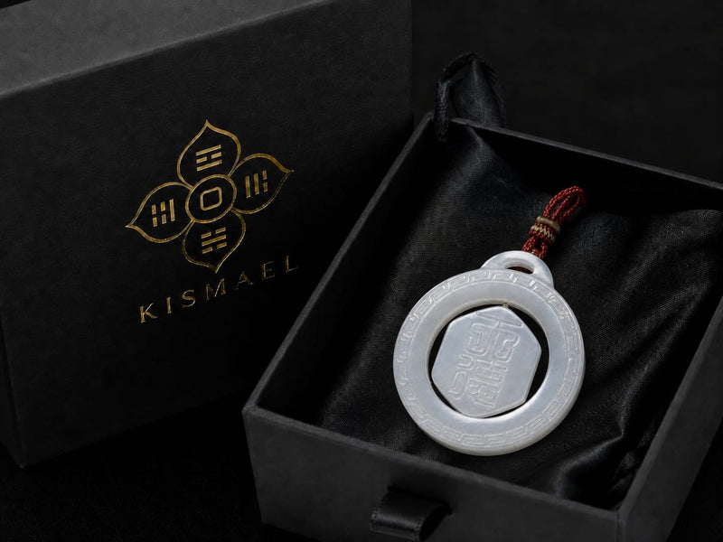 The Heavenly Blessing Talisman Pendant resting in a black KISMAEL gift box on black satin fabric, showcasing the pendant’s smooth jade surface and intricate engraving, highlighting secure and elegant presentation.