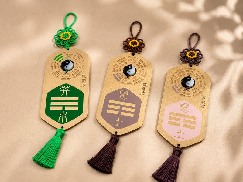 Three Missing Corner Plaques with different colors and tassels displayed on a table. The plaques are arranged to illustrate various symbolic placements for supporting multiple areas of a home’s Bagua energy map.