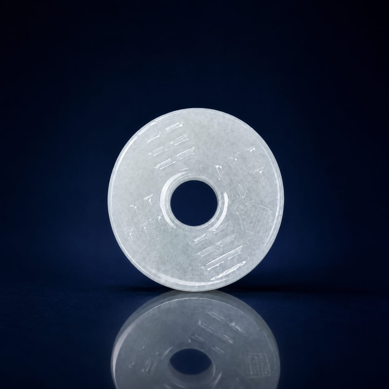 White Hetian jade Peace Buckle Pendant displayed on a dark reflective background, showing its circular shape, center opening, and polished jade surface.