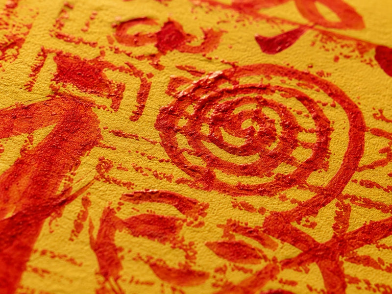 Macro detail of red protective symbols and seal-like markings on a golden Protection & Peace Talisman, representing peace, protection, balance, and inner calm.