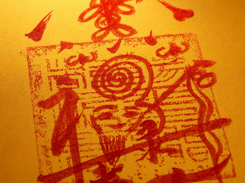 Close-up of red vermilion-style markings on a golden Protection & Peace Talisman, showing handmade brushwork texture inspired by traditional protective talisman symbols.