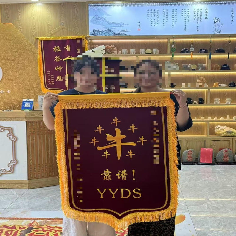Two clients holding a red and gold appreciation banner with "YYDS" inscription, showing recognition of the oracle guidance service.