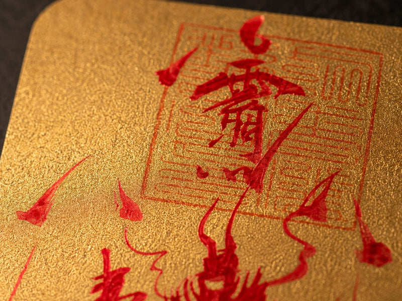 Close-up of the sacred seal and hand-brushed cinnabar red markings on gold talisman paper, showcasing the traditional Taoist brushwork and spiritual symbolism of Wang Lingguan.