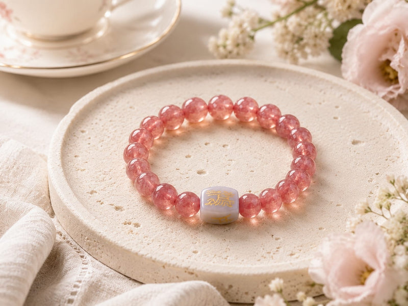 Natural Rhodochrosite bracelet with Hetian jade talisman bead placed on a round textured stone plate, showcasing the intentional arrangement and symbolic focal bead for emotional openness and gentle magnetism.