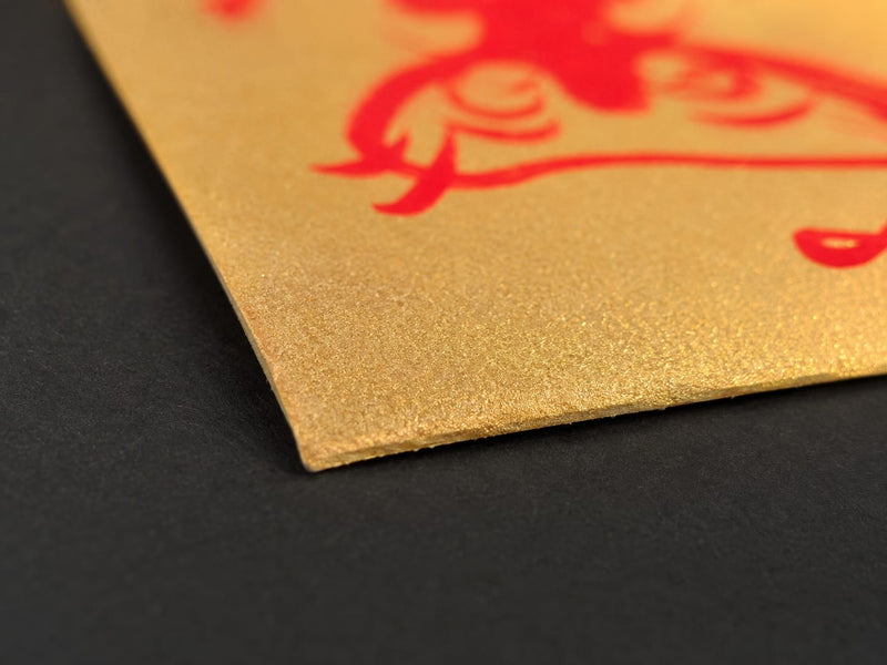 Close-up of the hand-cut edge of a golden Wealth Protection Talisman, highlighting the paper texture, handmade finish, and unique artisanal character.